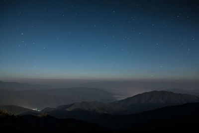 Scenic view of mountains against sky at night
