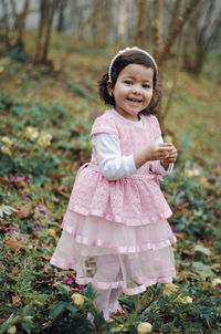 Portrait of happy girl standing on tree