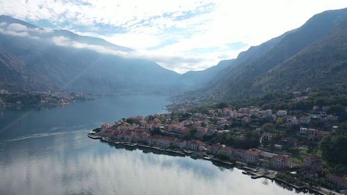 High angle view of townscape by lake against sky