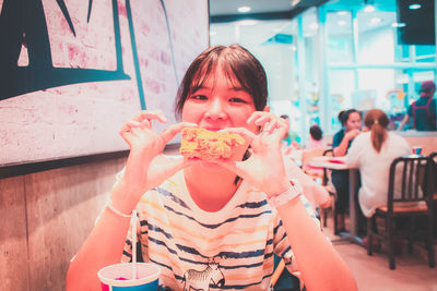 Portrait of woman eating food at restaurant