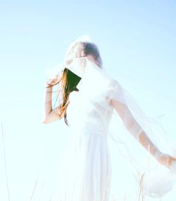 Low angle view of woman against clear sky