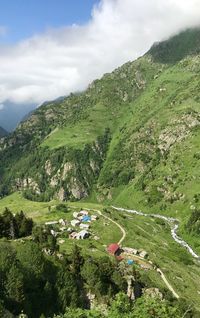 High angle view of green mountains against sky
