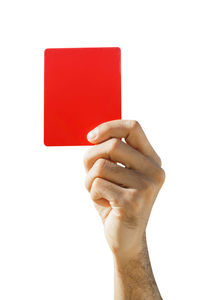 Close-up of hand holding book against white background