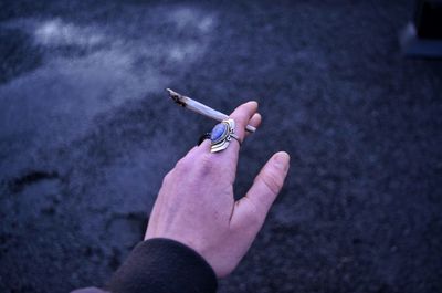 Close-up of hand holding cigarette