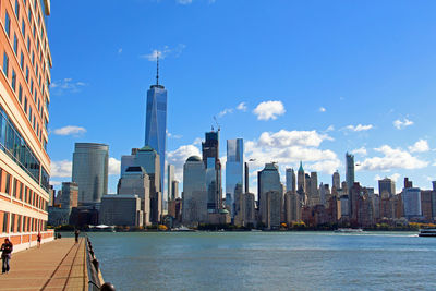 City at waterfront against blue sky