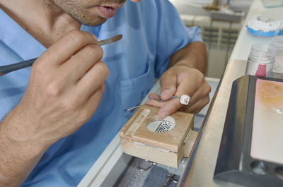 Close-up of dental worker cleaning dentures