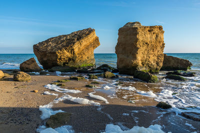 Rocks on beach against sky