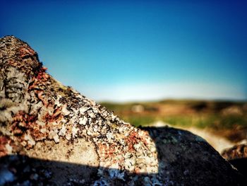 Close-up of rocks against clear blue sky