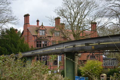 Bridge over buildings and trees against sky