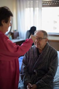 Woman checking temperature of patient