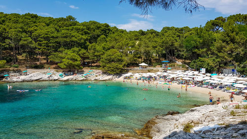 Beach full of people, emerald, water, sea, crowd, summer, vacation, mali losinj, croatia.