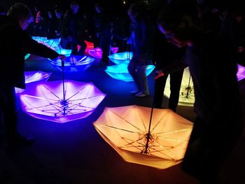 Close-up of illuminated lighting equipment hanging at night