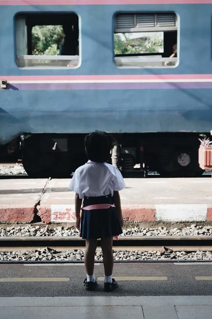 rear view, transportation, one person, real people, full length, mode of transportation, rail transportation, men, day, public transportation, land vehicle, lifestyles, travel, railroad station platform, casual clothing, walking, railroad track, train, railroad station, track, outdoors, waiting