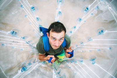 High angle view portrait of man in zorb ball