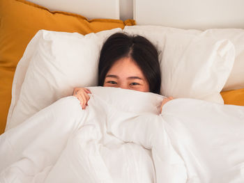 Portrait of young woman lying on bed