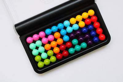 High angle view of multi colored blister pack over white background
