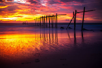 Scenic view of sea against dramatic sky during sunset