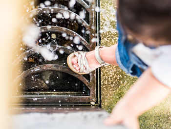 Low angle view of girl playing on fountain