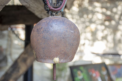 Close-up of rusty metal hanging against blurred background