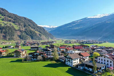 Houses on field by mountain against sky