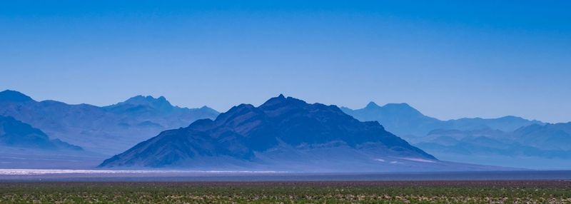 Scenic view of mountains against clear blue sky