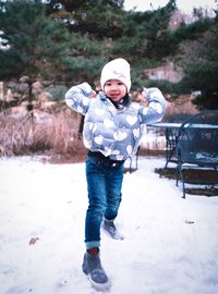 Full length portrait of happy girl playing in snow