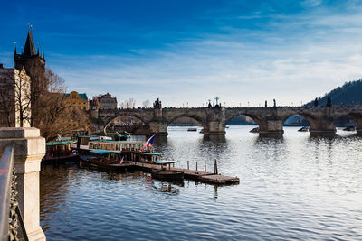 Bridge over river in city against sky