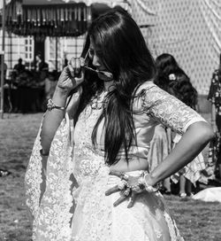 Woman with arms raised standing outdoors