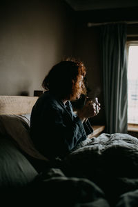 Side view of woman having coffee at home
