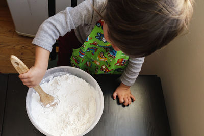 High angle view of boy preparing food on table
