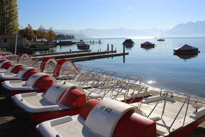 Boats moored in sea against clear sky