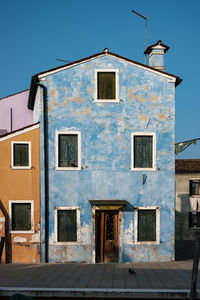 Low angle view of old building against clear blue sky