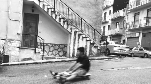 Side view of two people walking on street in front of buildings