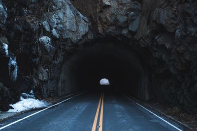 Empty road passing through tunnel