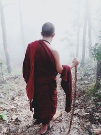 Rear view of man standing in forest