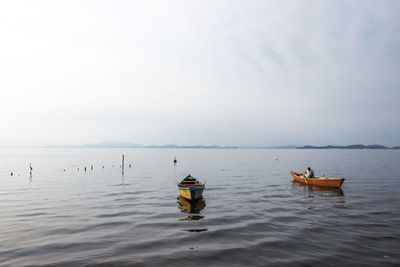 Boats on sea against sky