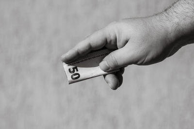 Cropped hand of person holding thermometer