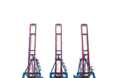 Low angle view of cranes against clear sky