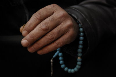 Close-up of person hand over black background