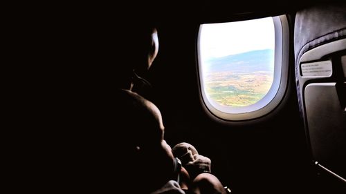 People looking through airplane window