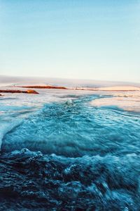 Scenic view of the tundra covered with snow and water in the spring sunset