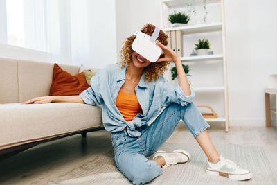 Young woman sitting on sofa at home