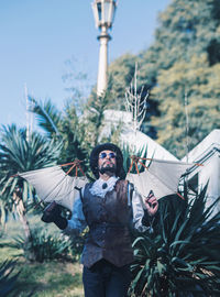 Portrait of young man standing against plants