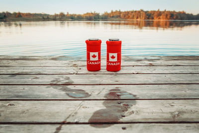 Red arrow sign on pier over lake