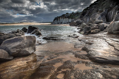 Rocks on beach against sky