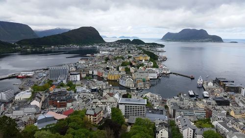 High angle view of cityscape by sea against sky