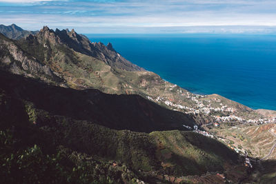 Panoramic view of sea and mountains against sky