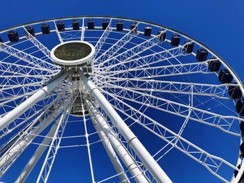 Low angle view of ferris wheel against blue sky