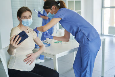 Female doctor injecting patient at clinic