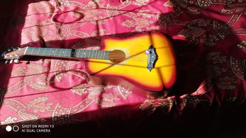 High angle view of guitar on bed